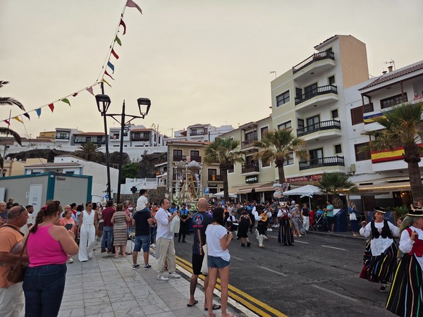 Fêtes de Candelaria Scène de fête populaire à Candelaria avec une procession, des musiciens et des habitants rassemblés dans la rue.