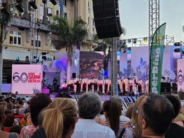 Concert en plein air de Los Sabandeños sur une scène éclairée devant un public nombreux.