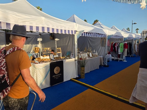 Allée d’un marché à Costa Adeje avec tentes blanches, stands d’artisanat et visiteurs.