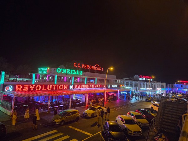 Vie nocturne à Playa de las Américas à Tenerife, avec enseignes lumineuses, bars animés et rue remplie de visiteurs.