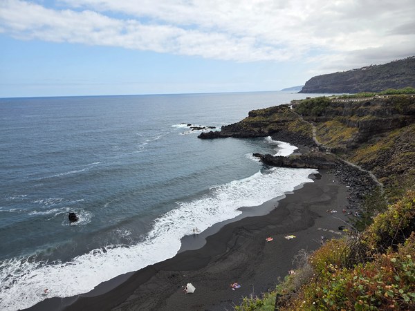 Playa El Bollullo à Tenerife, avec sable noir, falaises sauvages, vagues puissantes et côte volcanique spectaculaire.