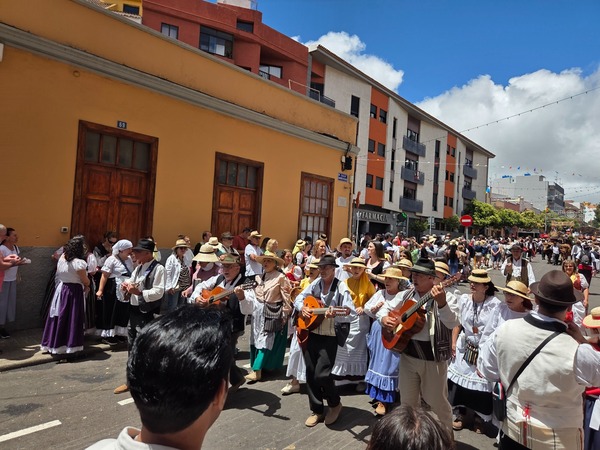 Défilé traditionnel de San Benito Abad avec musiciens, costumes typiques et foule dans la rue.