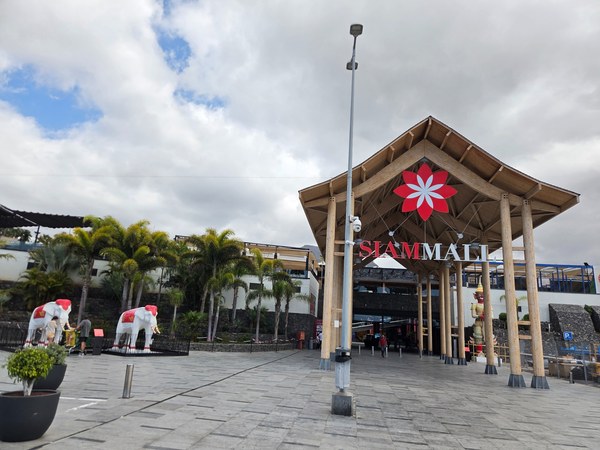 Entrée de Siam Mall Entrée de Siam Mall à Costa Adeje, avec grande structure en bois, palmiers et ciel nuageux.