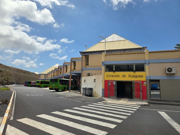 Gare routière de Costa Adeje avec bus verts TITSA stationnés devant le bâtiment principal.