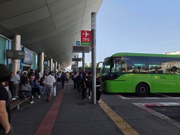 Quai de bus TITSA à Santa Cruz de Tenerife, avec voyageurs en attente sous l’auvent de la gare.