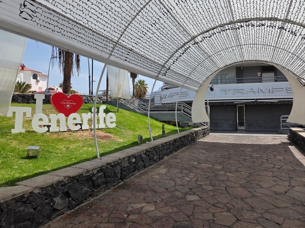 Enseigne I love Tenerife devant l’entrée du Tramps à Costa Adeje, sous une arche décorative lumineuse.